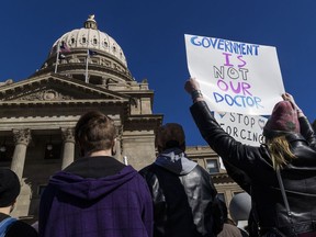 FILE - People gather in front of the Idaho Statehouse in opposition to anti-transgender legislation moving through an Idaho Republican congress, Friday, Feb. 24, 2023, in Boise, Idaho. The U.S. Supreme Court's decision on Monday, April 15, 2024, allows the state to put in place a 2023 law that subjects physicians to up to 10 years in prison if they provide hormones, puberty blockers or other gender-affirming care to people under age 18. A federal judge in Idaho had previously blocked the law in its entirety.
