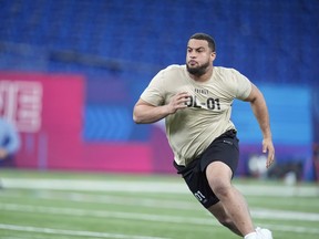 Illinois offensive lineman Isaiah Adams runs a drill at the NFL football scouting combine, Sunday, March 3, 2024, in Indianapolis.