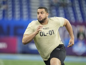 Illinois offensive lineman Isaiah Adams runs a drill at the NFL football scouting combine, Sunday, March 3, 2024, in Indianapolis. Adams remains the top-ranked player for the 2024 CFL draft.