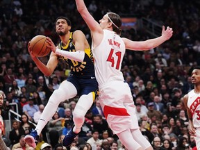 Indiana Pacers guard Tyrese Haliburton (0) drives to the net as Toronto Raptors forward Kelly Olynyk (41) defends during first half NBA basketball action in Toronto on Tuesday, April 9, 2024.