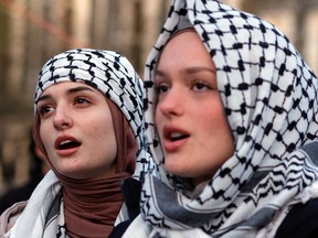 Two young women protesters wearing keffiyehs.