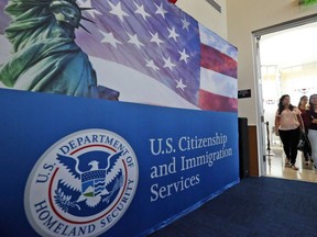FILE - People arrive before the start of a naturalization ceremony at the U.S. Citizenship and Immigration Services Miami Field Office in Miami, Aug. 17, 2018. Authorities say lottery bids for highly-educated worker visas plunged nearly 40% this year, claiming success against people who were "gaming the system" by submitting multiple, sometimes dubious, applications to unfairly increase their chances.