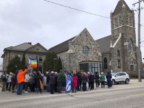 Protesters gather outside St. Joseph the Worker Church on March 17, 2024, in Beal City, Mich., in response to a priest's criticism of a gay author who read a book at a parish school. The Rev. Thomas Held resigned as pastor on April 16, 2024.