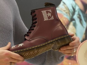 FILE - A Dr Martens boot inspired by Elton John's famous Pinball Wizard outfit is shown at a promotional event in London, March 20, 2023. Dr. Martens shares plunged more than 30% Tuesday, April 16, 2024 after the trendy British brand forecast that wholesale revenue in the U.S., its largest market, would decline by double-digits compared to that seen a year ago.