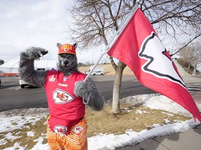 FILE - A Kansas City Chiefs fan, Chiefsaholic, poses for photos while walking toward Empower Field at Mile High before an NFL football game between the Denver Broncos and the Chiefs, Jan. 8, 2022, in Denver. An Oklahoma judge has ordered the Kansas City Chiefs superfan known as "ChiefsAholic" who admitted to a series of bank robberies to pay $10.8 million to a bank teller he threatened and assaulted with a gun.