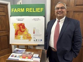 FILE - Missouri Treasurer Vivek Malek stands near a poster promoting drought conditions and state aid programs, Jan. 4, 2024, at his Capitol office in Jefferson City, Mo. Agricultural entities are among several categories of businesses that can receive low-interest loans backed by deposits of state funds made by the treasurer's office. Missouri lawmakers gave final approval Thursday, April 18, to significantly expand a low-interest loan program for farmers and small businesses.
