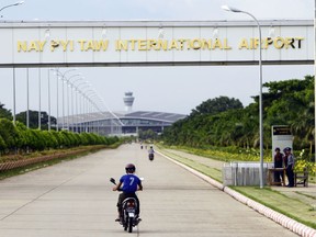 FILE - A resident drives motorbike to Naypyitaw International Airport as security police stand guard, Thursday, Sept. 29, 2016, in Naypyitaw, Myanmar. Myanmar's main pro-democracy resistance group said Thursday, April 4, 2024, its armed wing launched drone attacks on the airport and a military headquarters in the capital, Naypyitaw, but the country's ruling military said it destroyed or seized more than a dozen drones used in the attacks.