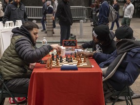 Tunde Onakoya, right, a Nigerian chess champion and child education advocate, plays a chess game in Times Square, Friday, April 19, 2024, in New York.