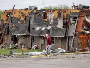 A man walks past tornado damage in Sulphur, Okla., Sunday, April 28, 2024, after severe storms hit the area the night before.