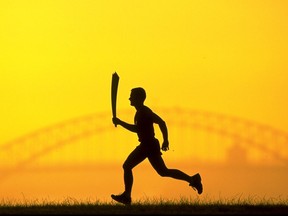 The Olympic Torch silhouetted against the Sydney Harbour Bridge on March 23, 1999.