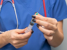 A doctor holding a syringe.