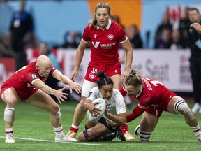 Canada's Krissy Scurfield, right, takes down New Zealand's Risi Pouri-Lane as Canada's Olivia Apps, left, and Caroline Crossley watch during Vancouver Sevens women's rugby semifinal action, in Vancouver, on Sunday, Feb. 25, 2024.