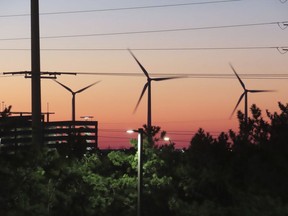 The sun sets behind spinning land-based wind turbines in Atlantic City, N.J., on Dec. 13, 2023. On April 24, 2024, eight Jersey Shore towns wrote to New Jersey utility regulators saying that a proposed wind farm off Long Beach Island will be costlier than expected.