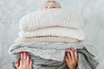 woman stacking sweaters