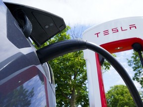 An electric vehicle is charged at a Tesla charging station