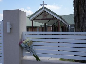 FILE - Flores sit on a fence outside the Christ the Good Shepherd church in suburban Wakely in western Sydney, Australia, on April 16, 2024. Detectives and secret service agents investigating the stabbing of a bishop in the Sydney church last week executed search warrants in the city on Wednesday, April 24, as part of a major operation, officials said.