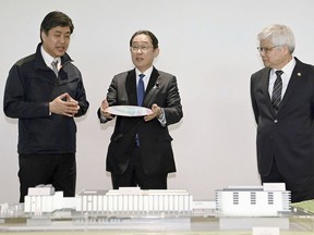 Japanese Prime Minister Fumio Kishida, center, is briefed as he visits a plant of the Taiwan Semiconductor Manufacturing Co. in Kikuyo town, Kumamoto prefecture, southern Japan Saturday, April 6, 2024. At right is Taiwan Semiconductor Manufacturing Company CEO C.C. Wei. (Japan Pool/Kyodo News via AP)