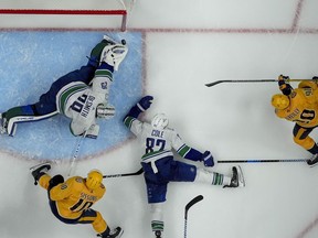 Vancouver Canucks goaltender Casey DeSmith (29) blocks a shot on goal by Nashville Predators center Ryan O'Reilly (90) during the third period in Game 3 of an NHL hockey Stanley Cup first-round playoff series Friday, April 26, 2024, in Nashville, Tenn. The Canucks won 2-1.