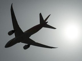 A plane is silhouetted as it takes off from Vancouver International Airport in Richmond, B.C., Monday, May 13, 2019. Authorities in the United States are investigating after a video surfaced on social media of a Colorado Rockies coach sitting in the cockpit of an aircraft "at cruise altitude."