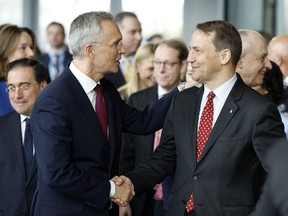 NATO Secretary General Jens Stoltenberg, left, shakes hands with Poland's Foreign Minister Radoslaw Sikorski a ceremony to mark the 75th anniversary of NATO at NATO headquarters in Brussels, Thursday, April 4, 2024. NATO marked on Thursday 75 years of collective defense across Europe and North America, with its top diplomats vowing to stay the course in Ukraine as better armed Russian troops assert control on the battlefield.