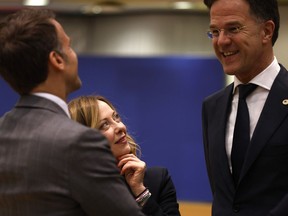 Italy's Prime Minister Giorgia Meloni, center, looks up at Netherland's Prime Minister Mark Rutte and French President Emmanuel Macron during a round table meeting at an EU summit in Brussels, Wednesday, April 17, 2024. European leaders' discussions at a summit in Brussels were set to focus on the bloc's competitiveness in the face of increased competition from the United States and China. Tensions in the Middle East and the ongoing war between Russia and Ukraine decided otherwise and the 27 leaders will dedicate Wednesday evening talks to foreign affairs.