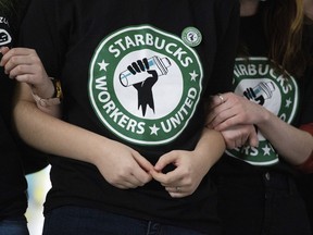 FILE - Starbucks employees and supporters link arms during a union election watch party Dec. 9, 2021, in Buffalo, N.Y. The U.S. Supreme Court is set to hear oral arguments in a case filed by Starbucks against the National Labor Relations Board.