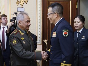 In this photo released by the Russian Defense Ministry Press Service on Friday, April 26, 2024, Russian Defense Minister Sergei Shoigu, left, shakes hands with Minister of National Defense of the People's Republic of China Dong Jun on the sidelines of the Shanghai Cooperation Organisation (SCO) Defense Ministers' Meeting in Astana, Kazakhstan.