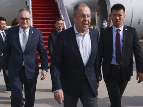 In this photo released by Russian Foreign Ministry Press Service on Monday, April 8, 2024, Russian Foreign Minister Sergey Lavrov, center, walks from the plane upon his arrival in Beijing, China. Russian Foreign Minister Sergey Lavrov is visiting Beijing to display the strength of ties with close diplomatic ally China amid Moscow's grinding war against Ukraine. (Russian Foreign Ministry Press Service via AP)