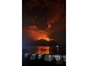 In this photo released by Sitaro Regional Disaster Management Agency (BPBD Sitaro), hot molten lava glows at the crater of Mount Ruang as it erupts in Sanguine Islands, Indonesia, Wednesday, April 17, 2024. Indonesian authorities issued a tsunami alert Wednesday after eruptions at Ruang mountain sent ash thousands of feet high. Officials ordered more than 11,000 people to leave the area. (BPBD Sitaro via AP)