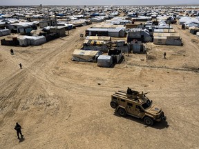 FILE - Kurdish forces patrol al-Hol camp, which houses families of members of the Islamic State group in Hasakeh province, Syria, on April 19, 2023. Kurdish-led authorities in northeast Syria handed over Thursday 50 family members of the Islamic State group fighters to a delegation from Tajikistan that escorted the repatriates back home.