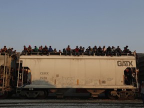 FILE - Central American migrants ride atop a freight train during their journey toward the US-Mexico border, in Ixtepec, Oaxaca State, Mexico, April 23, 2019. Oaxaca is a key route for migrants seeking to cross Mexico to reach the U.S. border, and accidents involving migrants there are common.