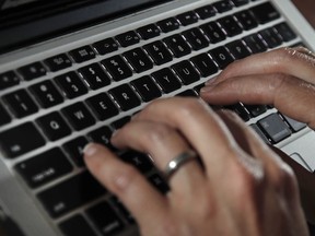 FILE - A person works on a laptop in North Andover, Mass., on June 19, 2017. Cyberattacks on businesses are rising, including small businesses. It's a troubling trend that can be very costly and time consuming if owners don't have a plan to deal with them.