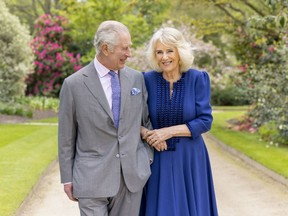 King Charles III and Queen Camilla stand in Buckingham Palace
