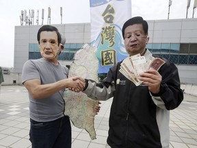 Protesters wearing masks of former Taiwanese President Ma Ying-jeou, left, and Chinese President Xi Jinping, right, perform, as Ma leaves for China outside of Taoyuan International Airport in Taoyuan City, Northern Taiwan, Monday, April 1, 2024.