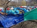 Anti-Israel demonstrators hang tarps to try to block the view into their encampment on the campus at McGill University on Wednesday May 1, 2024.
