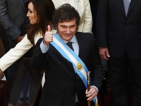 Argentina's new president Javier Milei gives the thumb up next to his vice-president Victoria Villarruel after receiving the presidential sash and baton from outgoing president Alberto Fernandez (out of frame) during his inauguration ceremony at the Congress in Buenos Aires on Dec. 10, 2023.