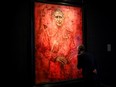 A visitor looks at the new red portrait of King Charles III, painted by British artist Jonathan Yeo, displayed at the Philip Mould gallery, on Pall Mall, central London, on May 16.