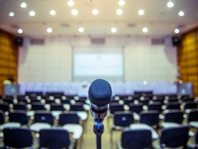 Microphone over a blurred conference hall.