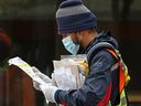 A Canada Post mail carrier delivers mail in Calgary on Monday, May 11, 2020.