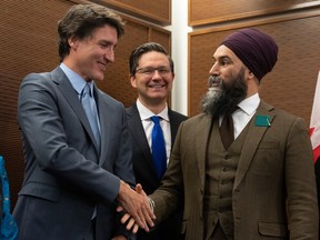 Prime Minister Justin Trudeau shakes hands with New Democratic Party leader Jagmeet Singh as Conservative leader Pierre Poilievre looks on at a Tamil heritage month reception on Jan. 30, 2023, in Ottawa.