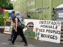 Supporters walk past a sign at the pro-Palestinian protest encampment on UQAM University campus, in Montreal, on May 27.