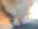 A wildfire burning near Fort Nelson, British Columbia, is seen through an airplane window on May 10, 2024.