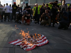 The American flag is set on fire during a demonstration in New York City in 2022.