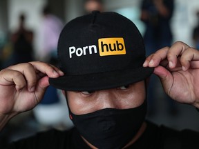 A man wearing a cap with the Pornhub logo