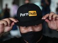 A man wearing a cap with the Pornhub logo