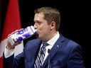 Conservative Leader Andrew Scheer drinks milk as he takes the stage at the National Press Gallery Dinner in Gatineau, Que., on June 3, 2017.