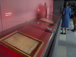 FILE - members of the media film four of the original surviving Magna Carta manuscripts that have been brought together by the British Library for the first time, during a media preview in London, Monday, Feb. 2, 2015. Two environmental activists have attacked a glass case containing an original copy of the Magna Carta at the British Library, causing minor damage to the re-enforced box but leaving the historic document unscathed on Friday, May 10, 2024.