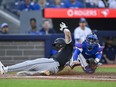 Chicago White Sox's Korey Lee (26) slides in to home ahead of the tag from Toronto Blue Jays catcher Danny Jansen (9) attempts to make a tag during second inning MLB baseball action in Toronto on Tuesday, May 21, 2024.
