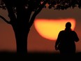 FILE - A woman watches the sun set on a hot day, Aug. 20, 2023, in Kansas City, Mo. A new study on Tuesday, May 14, 2024, finds that the broiling summer of 2023 was the hottest in the Northern Hemisphere in more than 2,000 years.