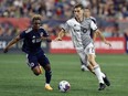 Toronto FC's Jordan Perruzza (77) and New England Revolution's Latif Blessing (19) compete during the second half of an MLS soccer match, in Foxborough, Mass., Saturday, June 24, 2023.